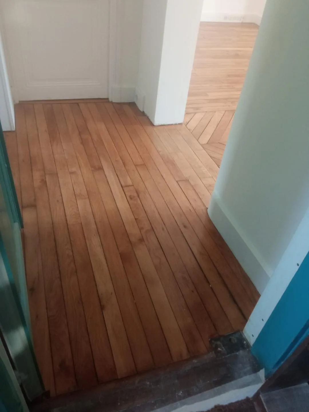 Entrée ouvrant sur deux pièces au parquet vitrifié