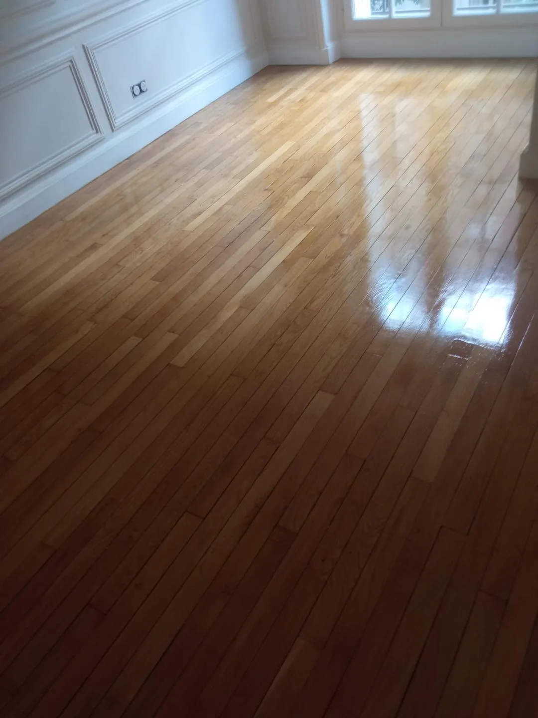 Pièce aux murs moulurés avec parquet vitrifié, livrée après rénovation